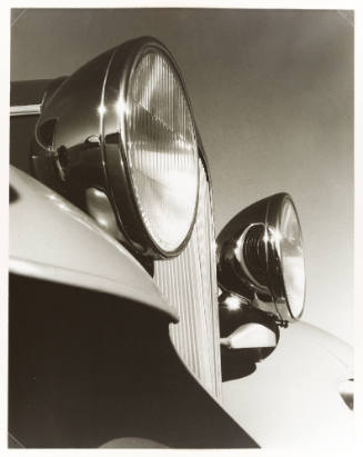 Close-up of the headlights, fender, and grill of a car