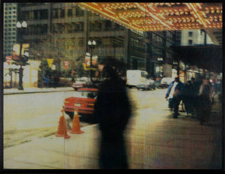Blurry photo of a city sidewalk with a large shadowy figure in the foreground