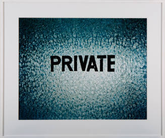 Close-up of a backlit frosted window stenciled with the word “PRIVATE”