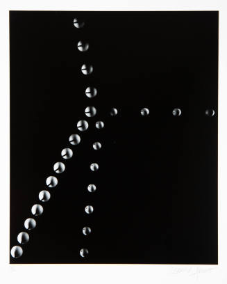 Black-and-white stop motion photo capturing two balls colliding on a dark background