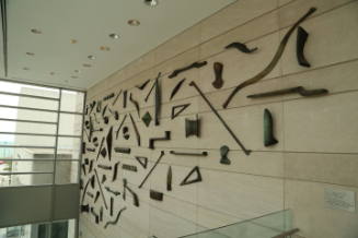 73 objects, including bones and tools, arranged in a triangular shape on the wall 