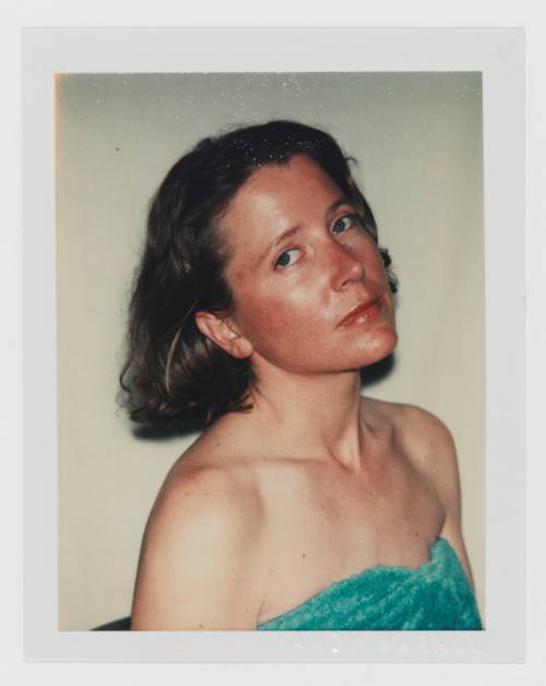 Polaroid of fair-skinned woman with blonde hair looking at camera in strapless shirt or towel