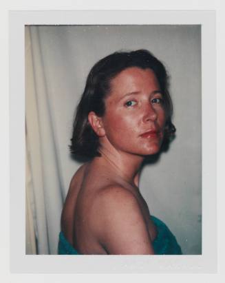 Polaroid portrait of light-skinned woman with dark blonde hair looking over shoulder toward camera
