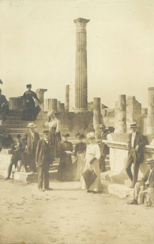 Group of people looking at us, seated and standing in ancient Greek or Roman ruins