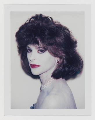 Polaroid of woman with dark feathered hair, white cakey makeup, red lipstick, and large jewelry
