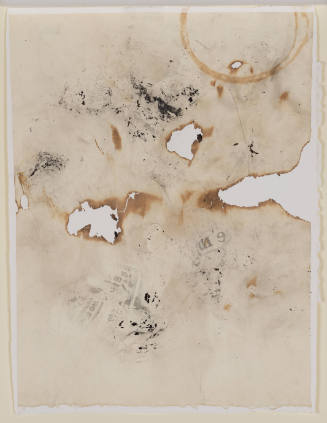 Tan paper, burnt through in several spots, with newspaper transfers and other dark marks and stains