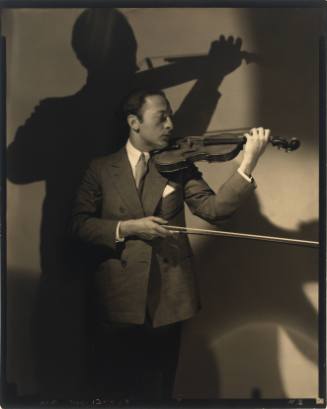 Man in suit with medium-light skin tone and violin on shoulder, positioned as if about to play