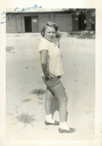 Light-skinned female-presenting person in shorts and shirt; photo inscribed “friend” in upper left