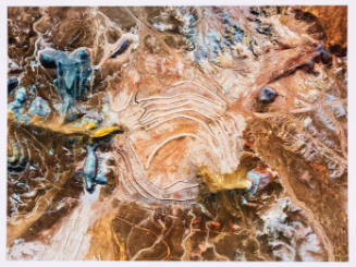 Color aerial photograph of a desert with hills, dry washes, and signs of industrialization