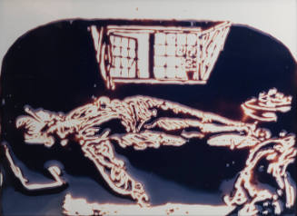 Photograph of chocolate rendering of man sprawled across a surface in front of a window.