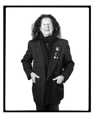 Portrait of artist Jaune Quick-to-See Smith from the knees up with her hands in coat pockets