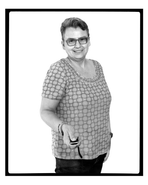 Black-and-white portrait of Rosalie Favell looking into camera holding remote trigger