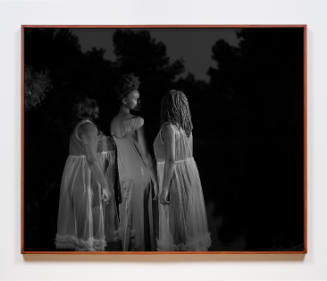 Three Black women in nightgowns stand close together before dark trees at night
