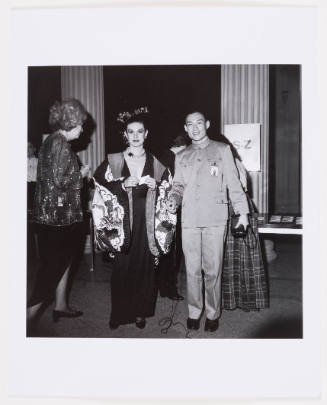  Black-and-white photograph of a woman in a silk jacket and a man wearing a Mao suit at a museum