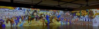 Brightly colored fairground scene; world leaders ride a carousel in center flanked by huge crowds