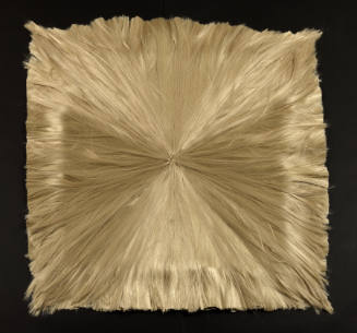 Bundle of blond synthetic hair knotted in center, spread in radial pattern and trimmed into a square