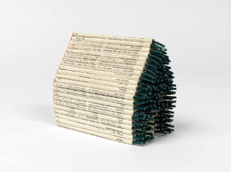 Log cabin assembled from stacked firecrackers that are covered with paper that has printed text