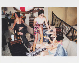 Five people, some in lingerie or little clothing, on a couch with alcohol bottles and glasses around