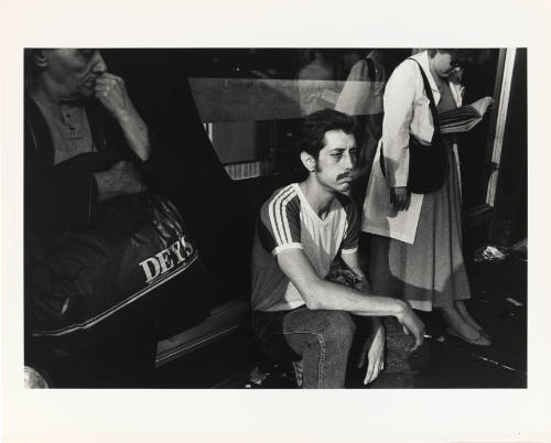 Three people leaning against a store window, the central figure is exhaling smoke from a cigarette