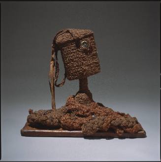 Abstract cylindrical human bust with button eye and a base of made of piled yarn with wood fragments