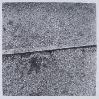 Close-up, black-and-white square photo of a horizontal curb with gravel on both sides