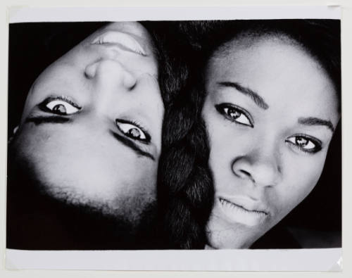 Close-up photo of two women’s faces looking at camera: one is upright, the other upside down