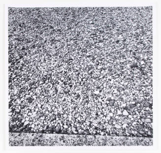 Black-and-white close-up photograph of the ground covered in gravel